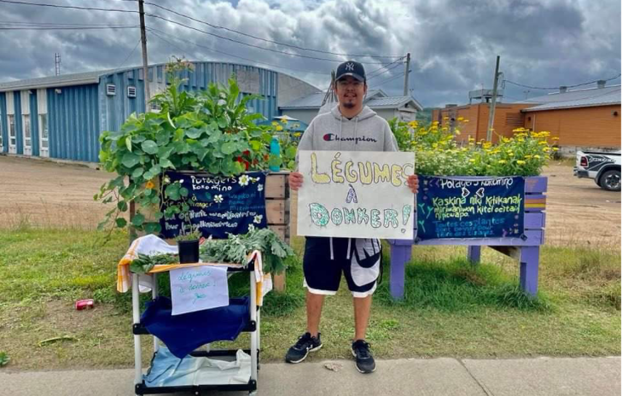 Homme se tenant debout avec une pancarte légumes à donner